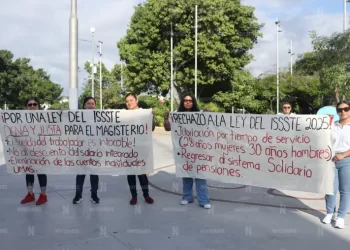 Maestros y maestras marchando con pancartas en protesta contra la reforma a la Ley del ISSSTE.