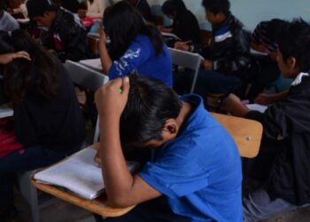 Estudiantes en un aula realizando una prueba estandarizada.