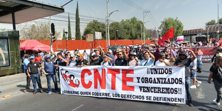 Docentes en una protesta con pancartas exigiendo cambios en la legislación educativa y en el sistema de pensiones.
