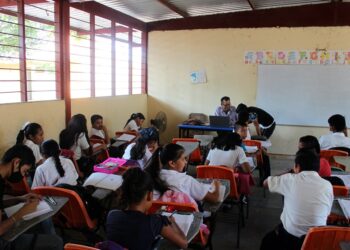 Niños en un aula sonrientes mientras aprenden a través del juego.