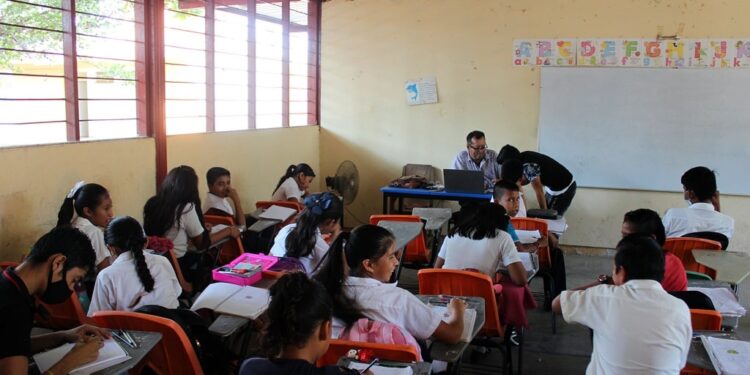 Niños en un aula sonrientes mientras aprenden a través del juego.