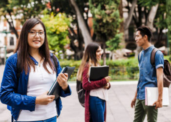 Estudiantes mujeres de bachillerato participando activamente en el aula con materiales educativos.