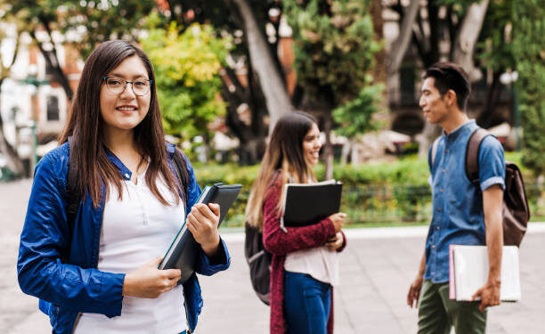 Estudiantes mujeres de bachillerato participando activamente en el aula con materiales educativos.