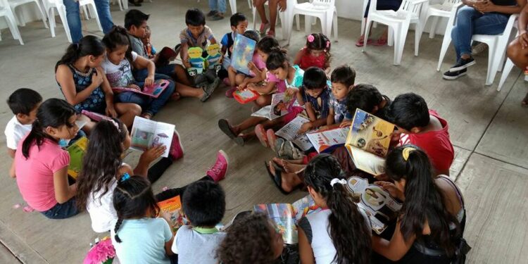 Niño leyendo solo en un hogar sin libros, en contraste con un entorno familiar lector.