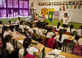 Un maestro orienta con cercanía a una estudiante en su proceso de aprendizaje.