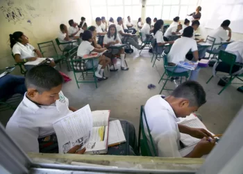 Estudiantes de primaria en América Latina trabajando en el aula; muchos enfrentan dificultades en comprensión lectora y matemáticas.