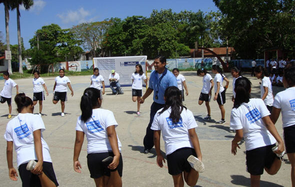 Niños en uniforme escolar participando en rutina de ejercicio como parte del programa Vive Saludable.