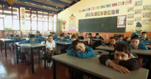 "Estudiantes de primaria despidiéndose de su maestra en una escuela rural de Jalisco, con expresiones emotivas y vínculos visibles."
