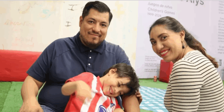 Niño jugando en un entorno escolar con adultos atentos.