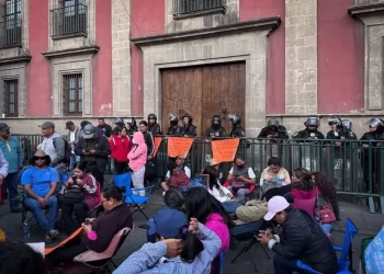 Fotografía de maestras y maestros de la CNTE en plantón frente a Palacio Nacional con pancartas por justicia laboral y social.