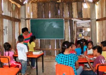Niños en una escuela rural mexicana con mobiliario básico