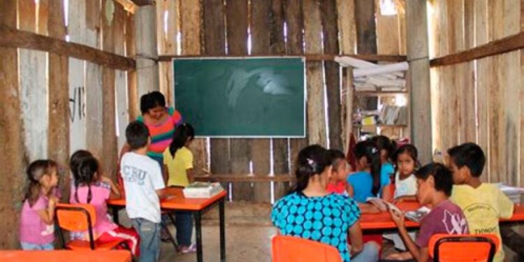 Niños en una escuela rural mexicana con mobiliario básico